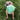 Pitbull dog sitting in grass with a teal pufferfish dog ball toy in its mouth