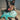Australian Shepherd laying down with teal starfish and teal pufferfish dog toys