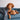 Brown dog laying on a blue couch and cuddling a Biscuit colored Snuggle Puppy anxiety relief dog toy