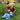Brown dog laying in grass and playing with a small and soft blue bear dog toy