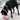 Black dog with orange bandana outside on driveway and playing with pink pig ball-shaped dog toy